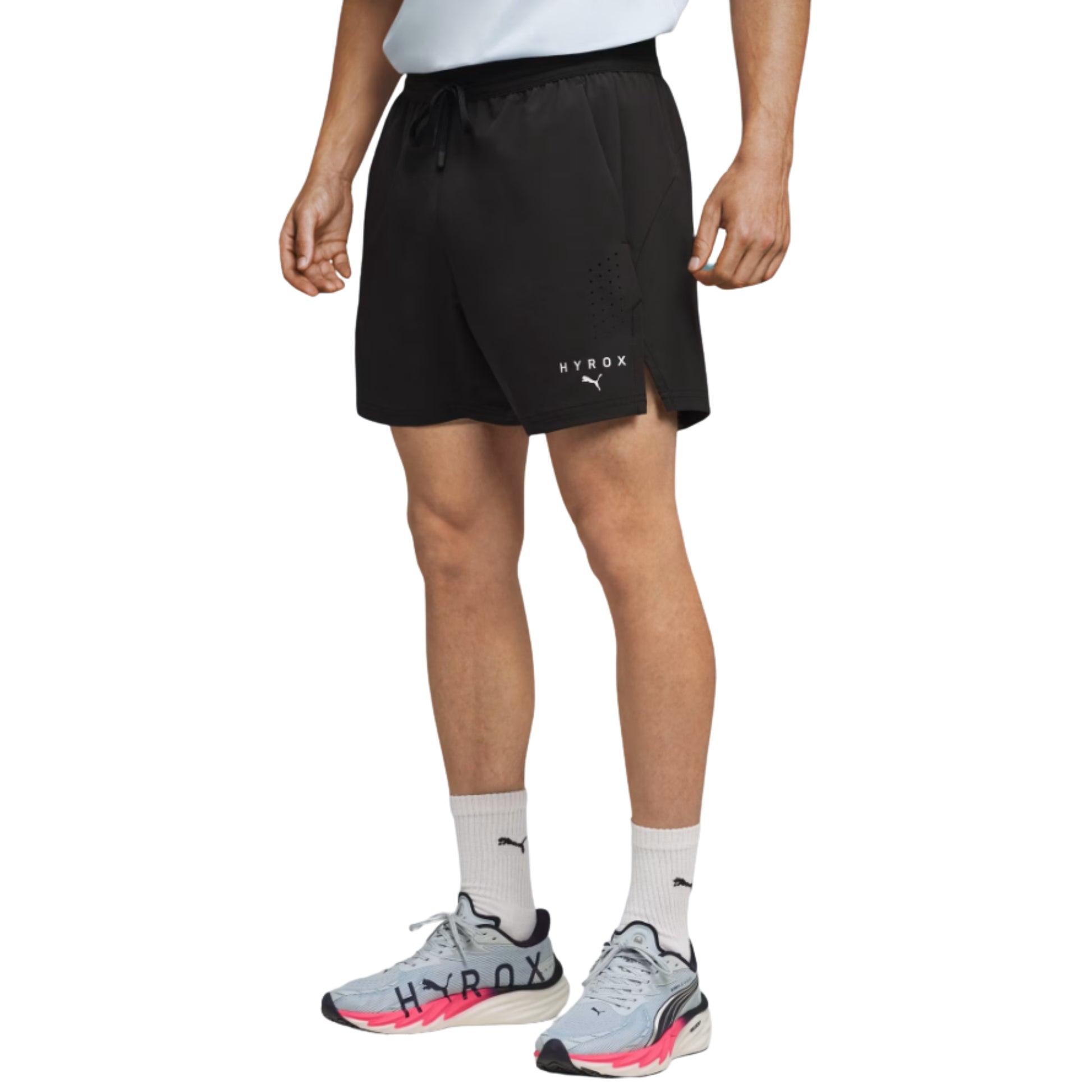 Person wearing black Puma shorts with a brand logo on a white background