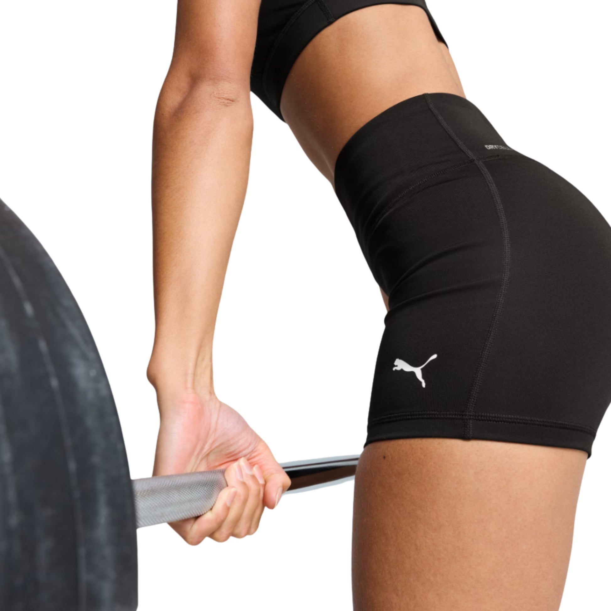 Person lifting a barbell wearing black Puma tights with a logo on a white background