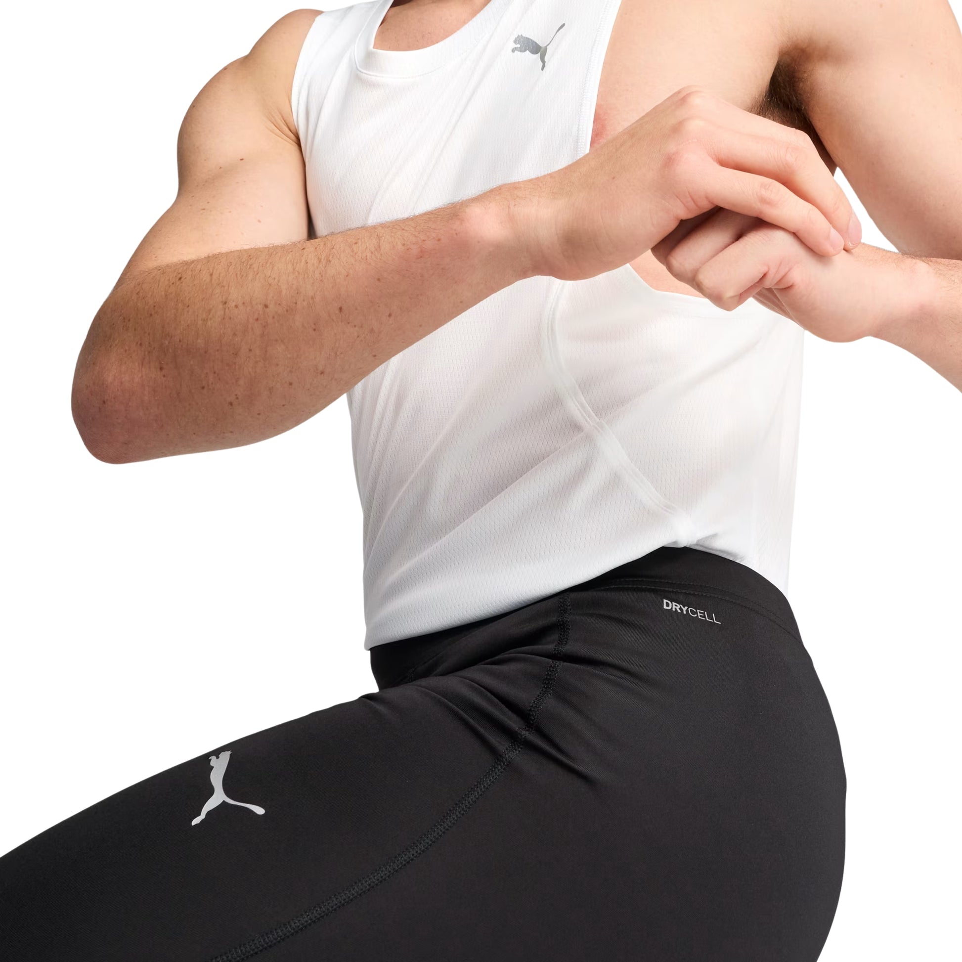Person wearing a white tank top and black Puma tights with a brand logo on a white background