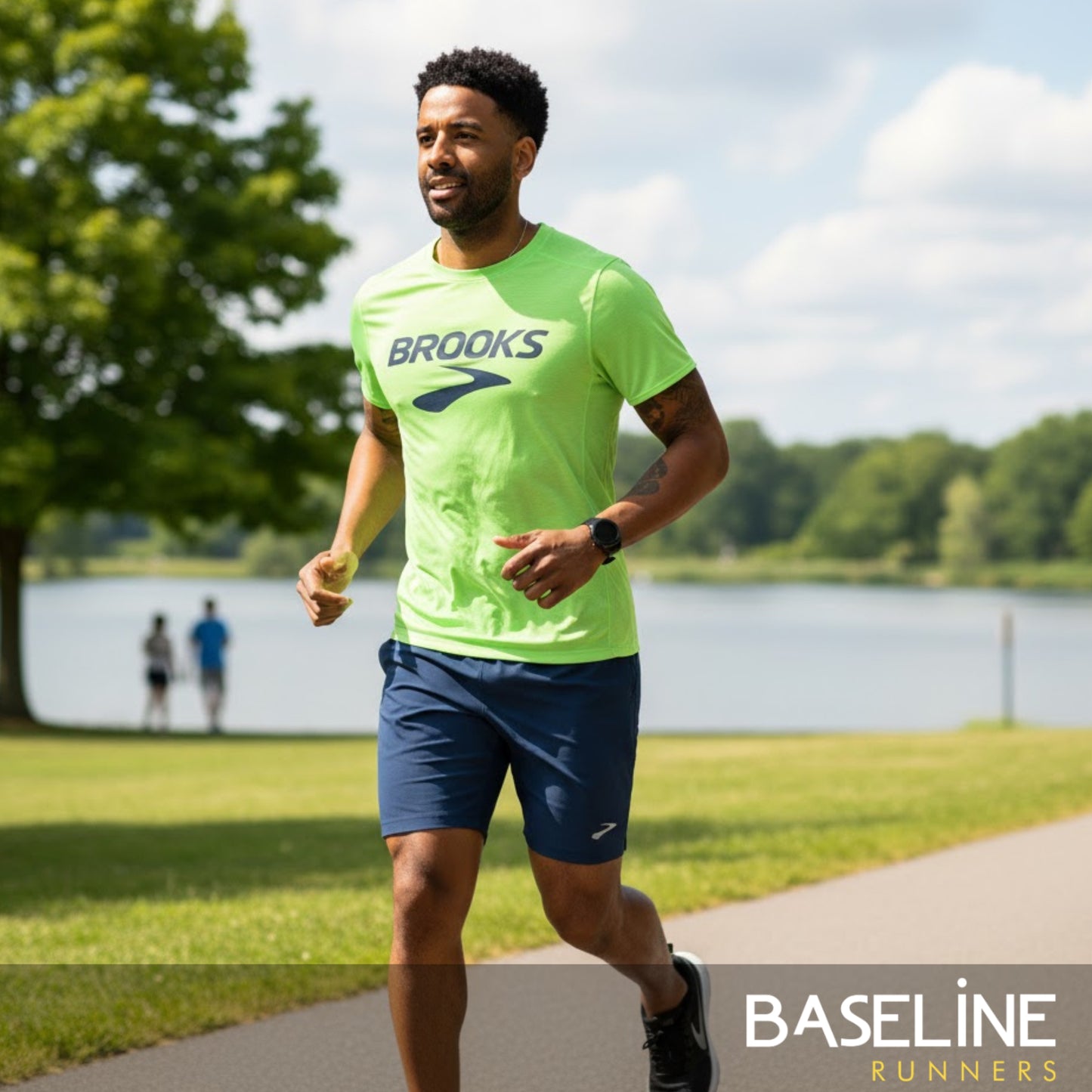 Man running outdoors wearing a Brooks shirt with a lake and trees in the background