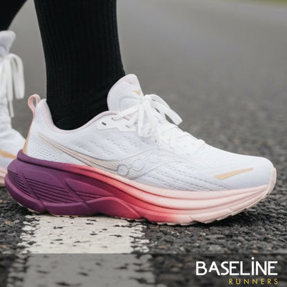 White running shoe with purple and pink gradient sole on a road, featuring 'Baseline Runners' branding.