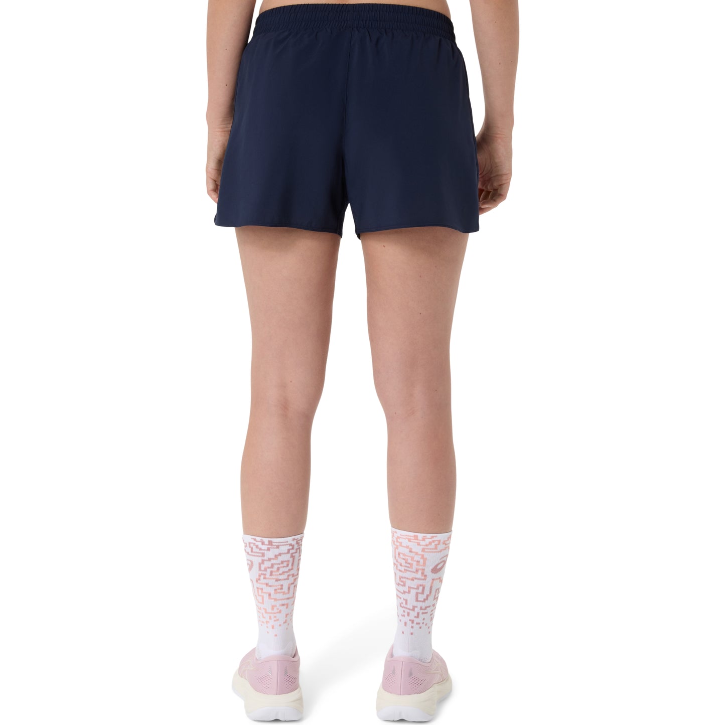 Person wearing navy Asics shorts and white socks with pink accents on a white background