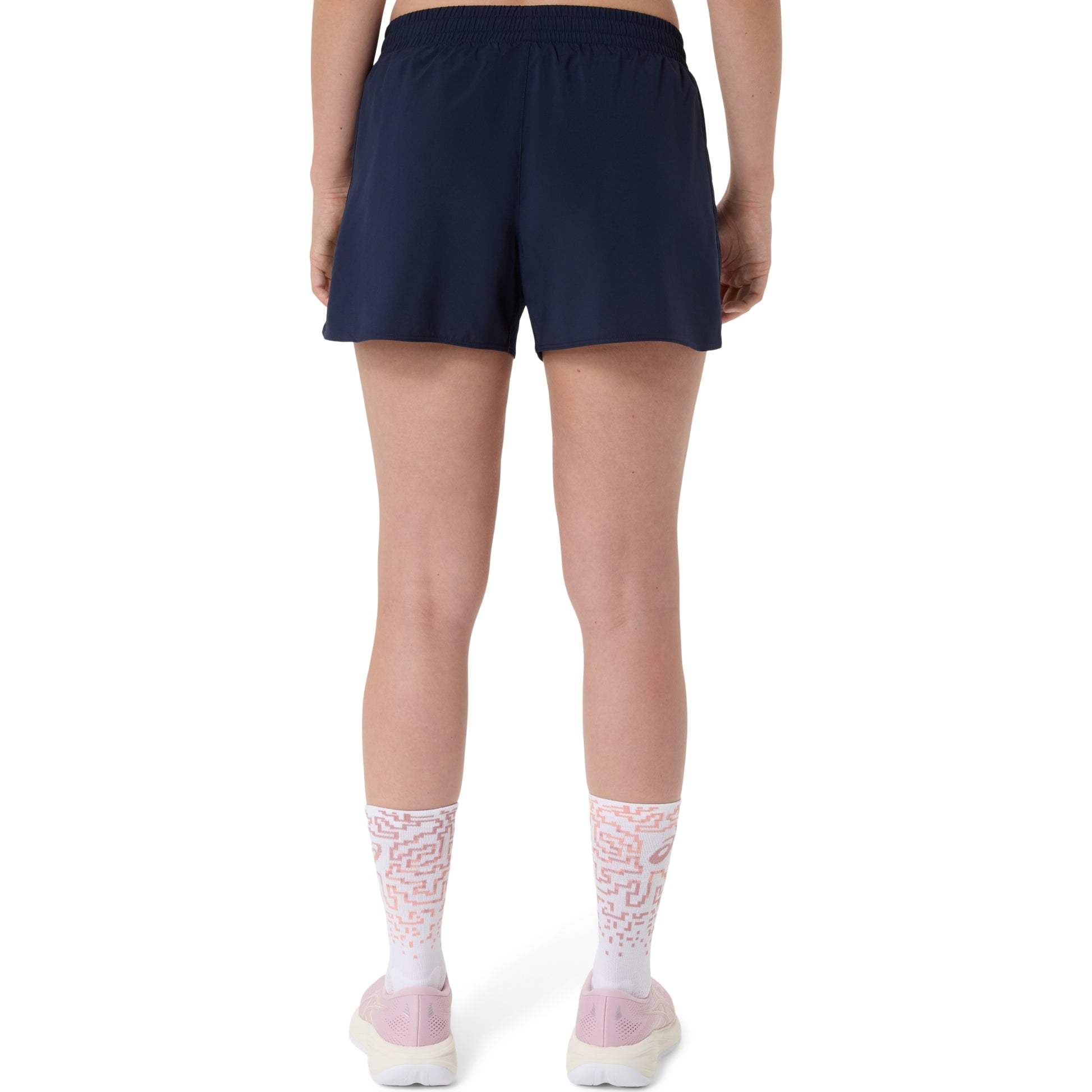 Person wearing navy Asics shorts and white socks with pink accents on a white background