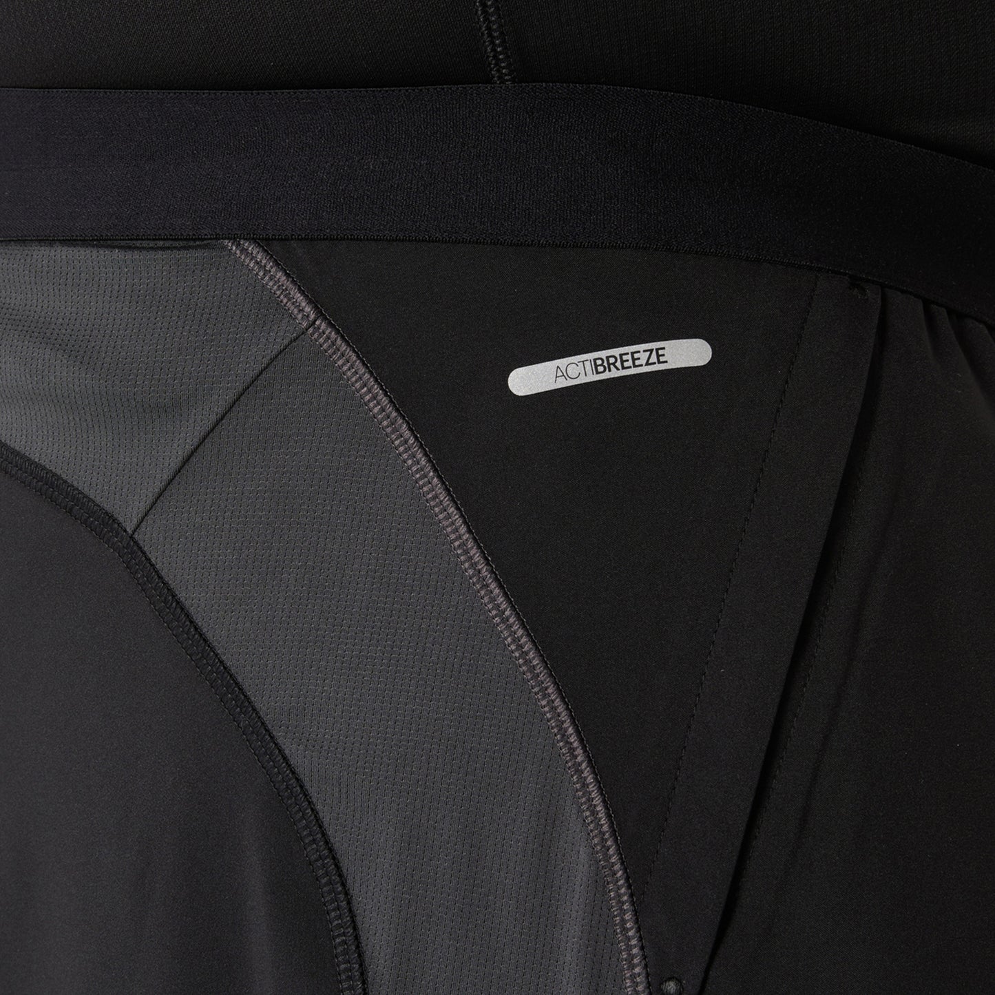 Close-up of a black and gray Asics shorts with 'ActiBreeze' label