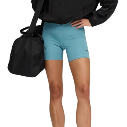 Person wearing light blue Puma tights with a black bag on a white background