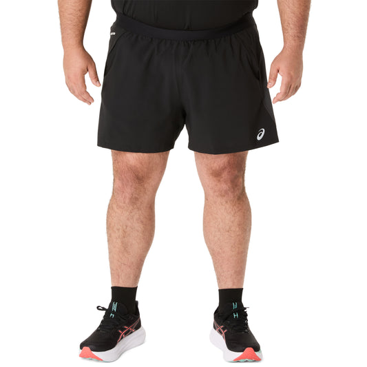 Person wearing black Asics running shorts on a white background