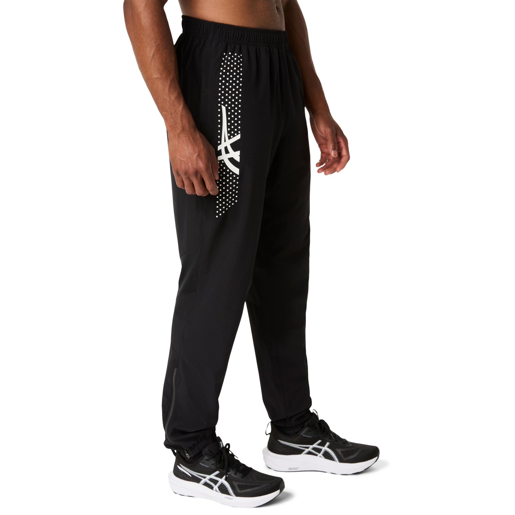 Person wearing black athletic pants with a white logo on a white background
