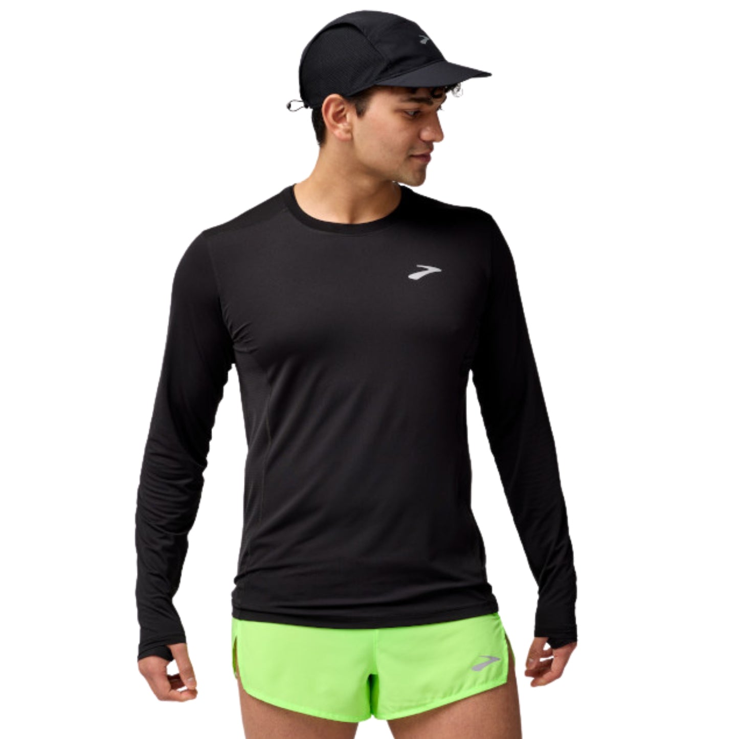 A man wearing a black long-sleeve athletic shirt with a small white logo on the left chest, paired with bright neon green shorts and a black cap, against a plain white background.