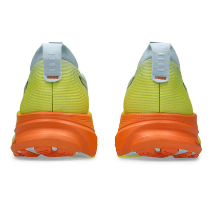 Back view of white and yellow Asics running shoes with orange soles on a white background