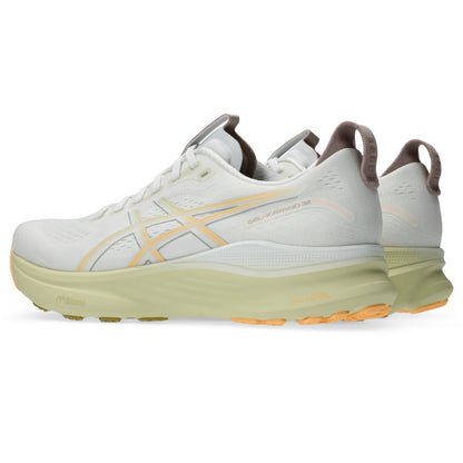 White Asics running shoes with orange soles on a white background