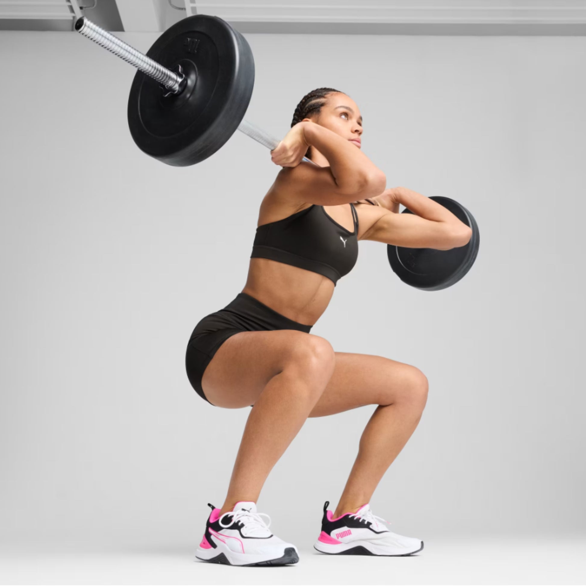 Woman wearing Puma outfit lifting a weight