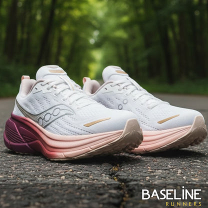 White and pink running shoes on a road with a blurred green background