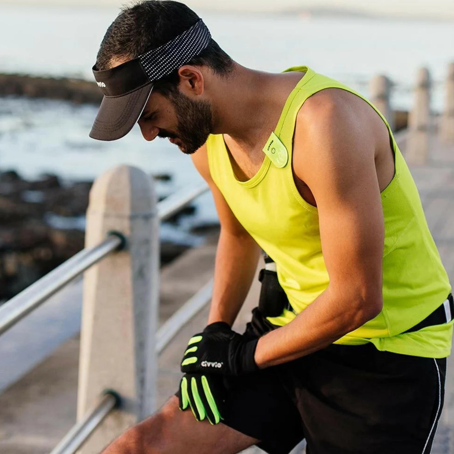 Man in athletic wear sitting by a waterfront