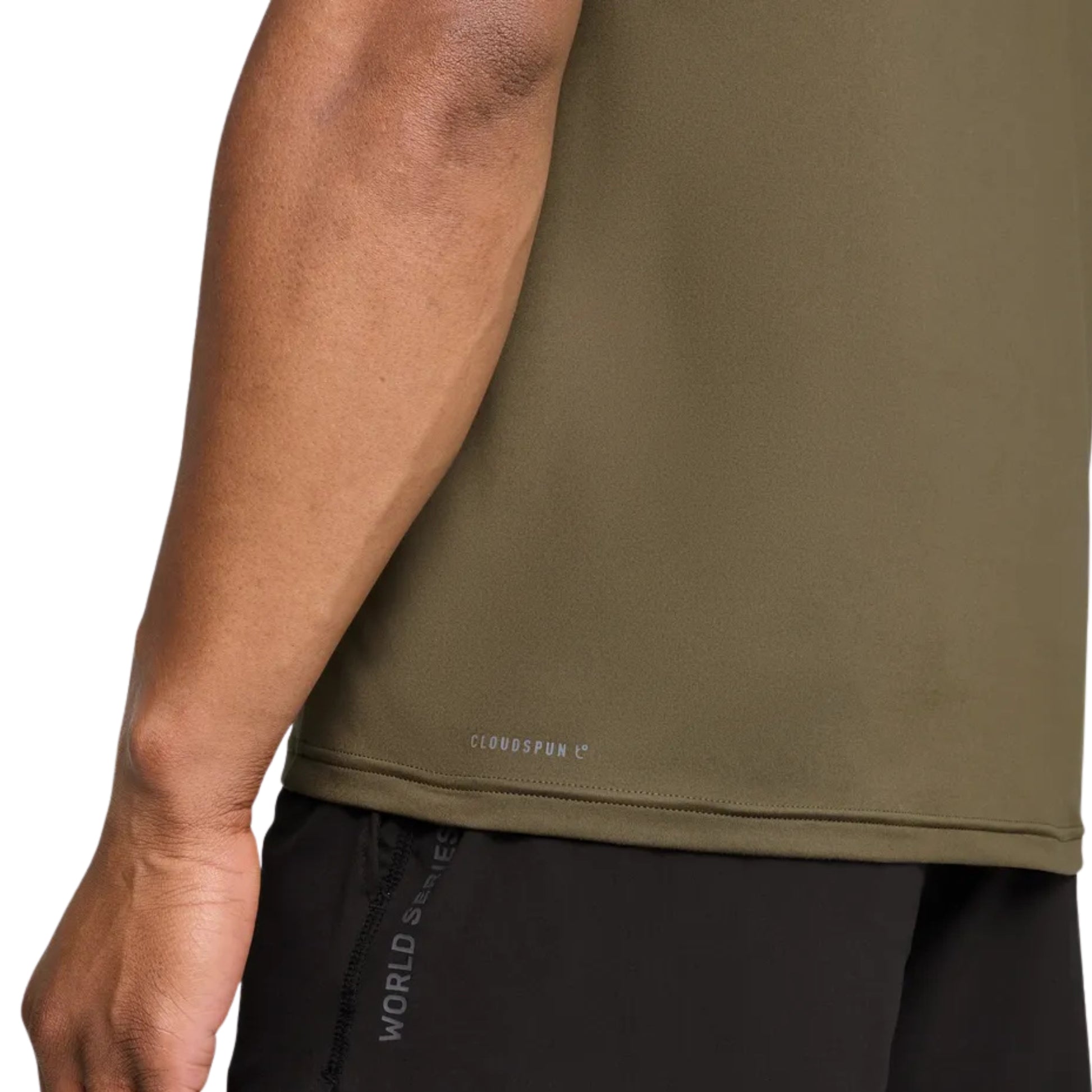 Person wearing a green athletic shirt with a visible brand logo on a white background