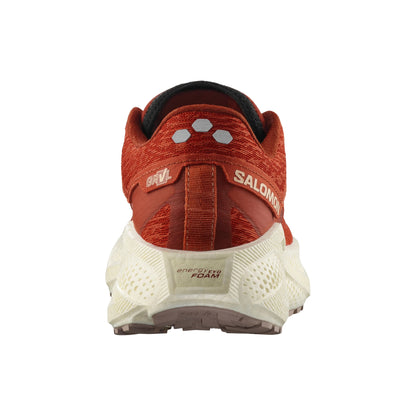 Red Salomon running shoe with white sole on a white background