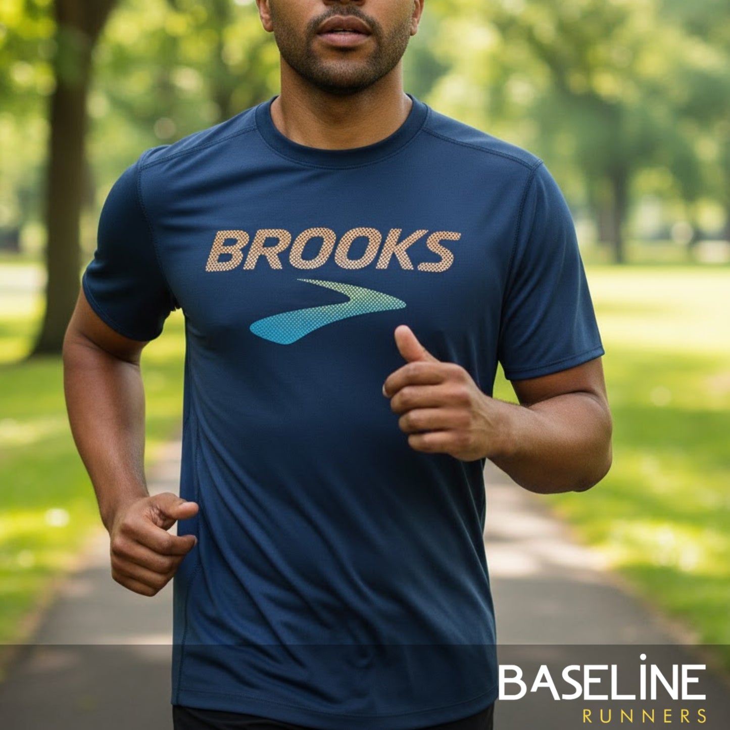 Man running outdoors wearing a blue 'Brooks' t-shirt with a blurred background