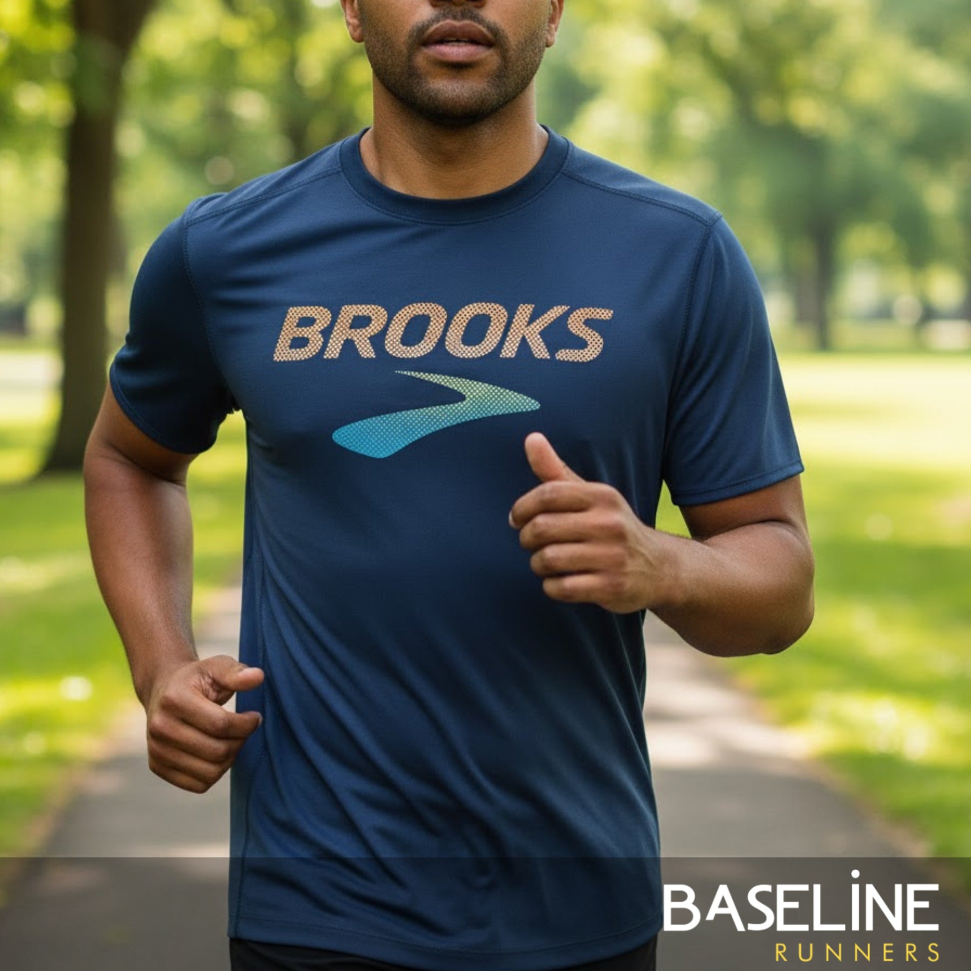 Man running outdoors wearing a blue 'Brooks' t-shirt with a blurred background