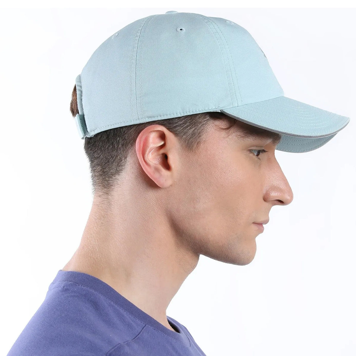 Person wearing a light blue Puma cap on a white background
