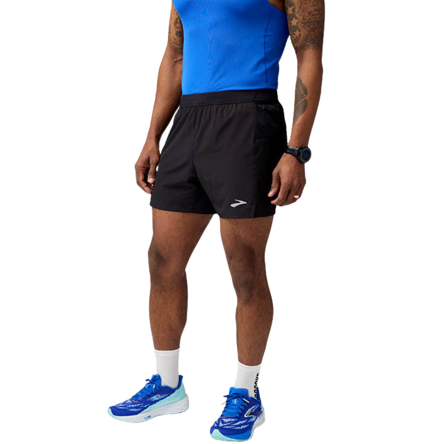 Person wearing black running shorts, blue tank top, and blue running shoes on a white background