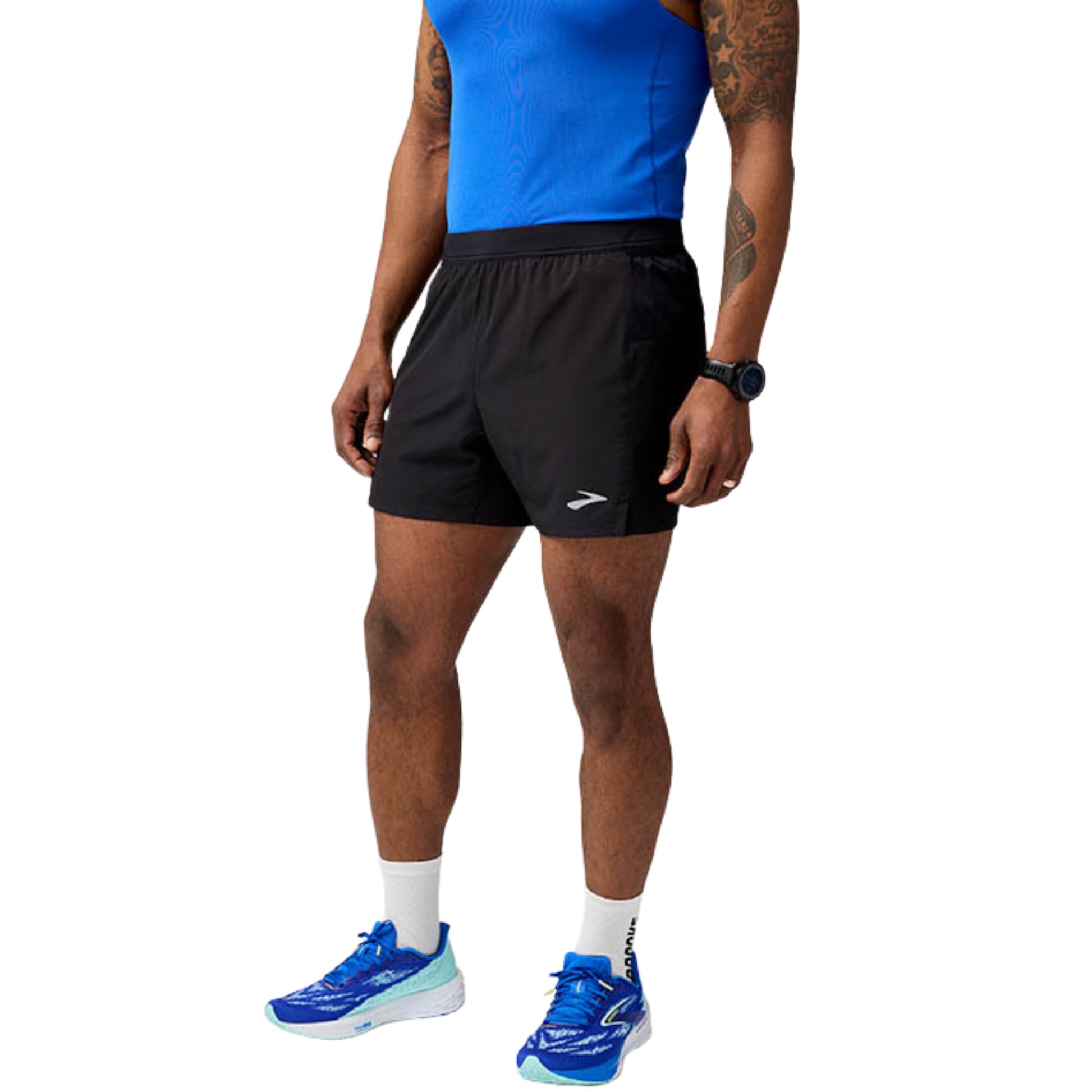 Person wearing black running shorts, blue tank top, and blue running shoes on a white background