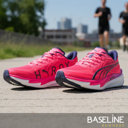 Pink Puma running shoes with 'Hyrox' text on a road with people running in the background.