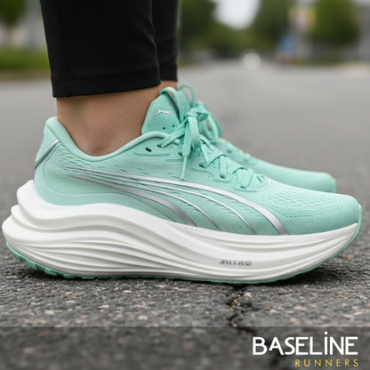 Mint green running shoe with white sole on a road, brand 'Puma' visible