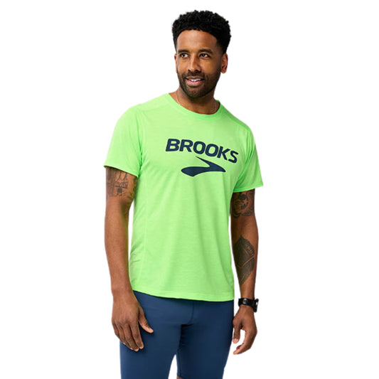 Man wearing a green Brooks t-shirt on a white background