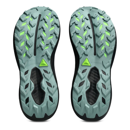 The outsoles of a pair of trail running shoes, featuring a muted teal-green tread pattern with bright neon green accents and a black center channel, shown against a plain white background.