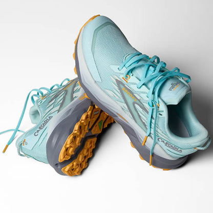 Light blue running shoes with orange soles on a white background