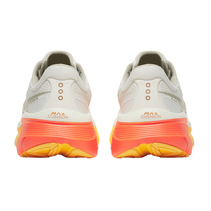 Pair of white Saucony running shoes with orange and yellow sole on a white background