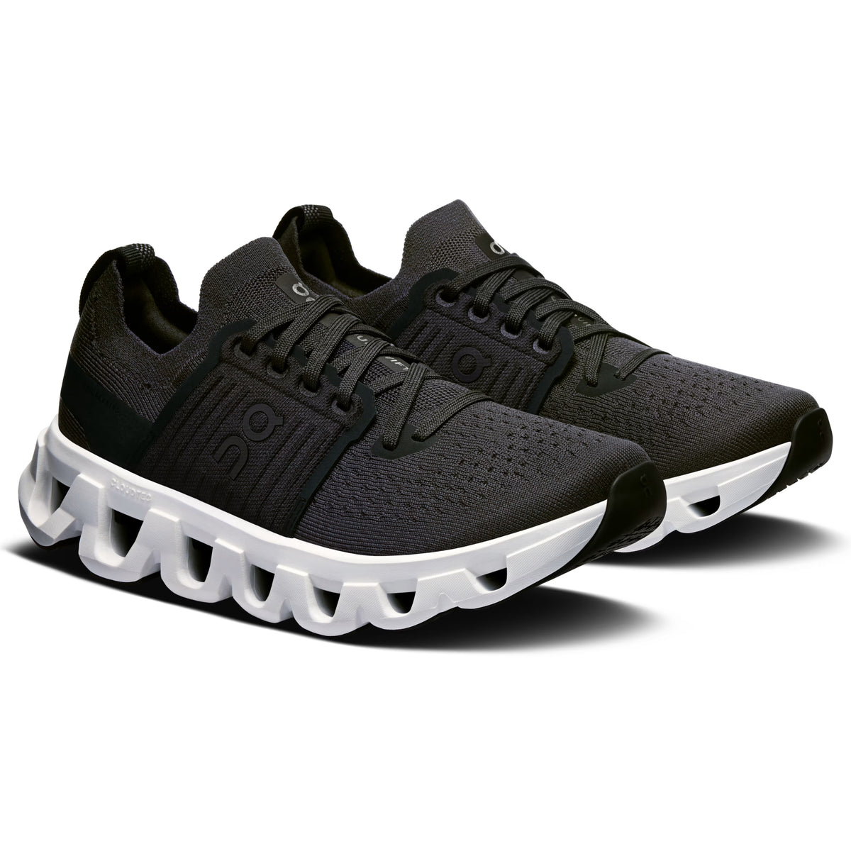 A pair of black On running shoes with a distinctive white sculpted sole, displayed on a clean white background.