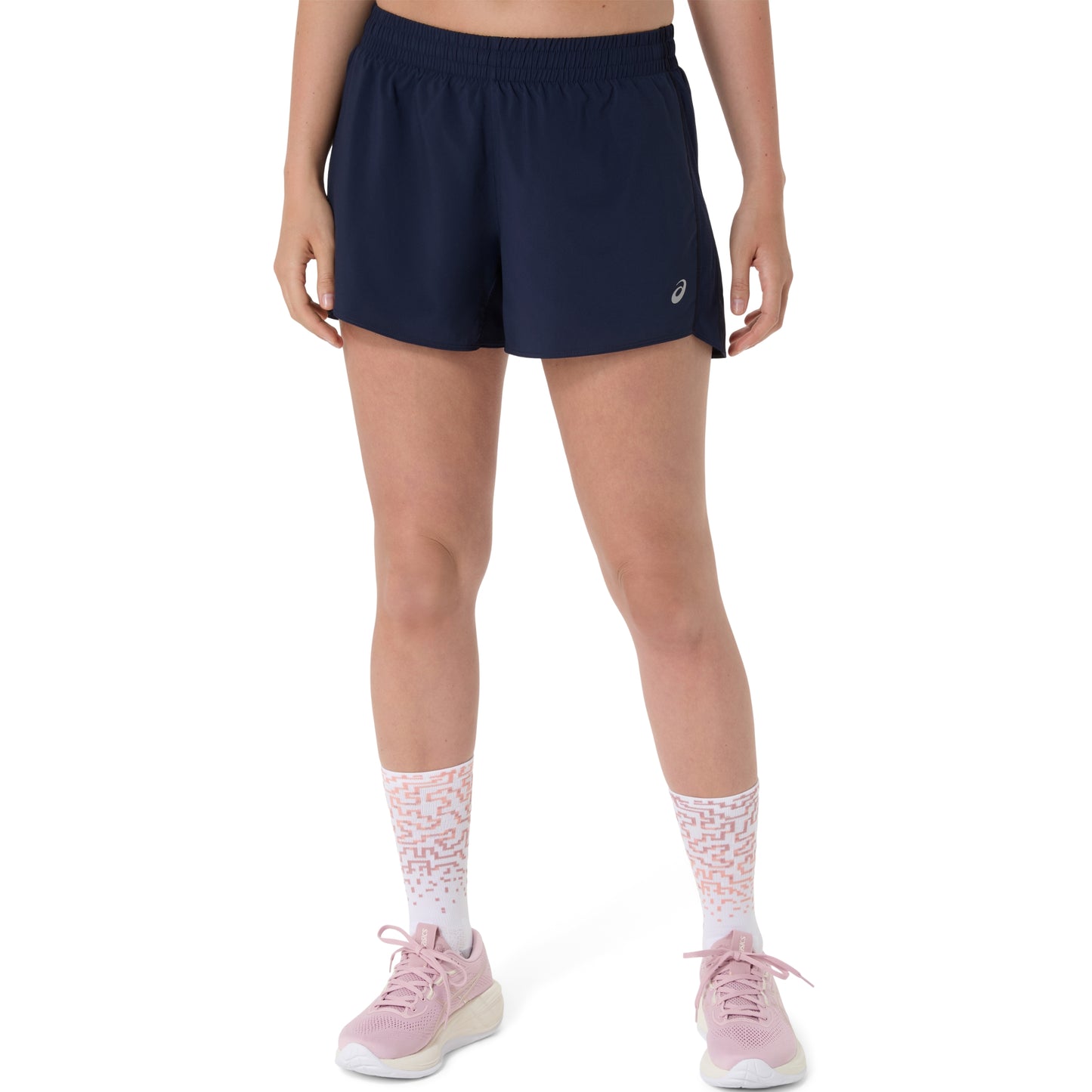 Person wearing navy Asics shorts with a brand logo on a white background