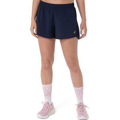 Person wearing navy Asics shorts with a brand logo on a white background