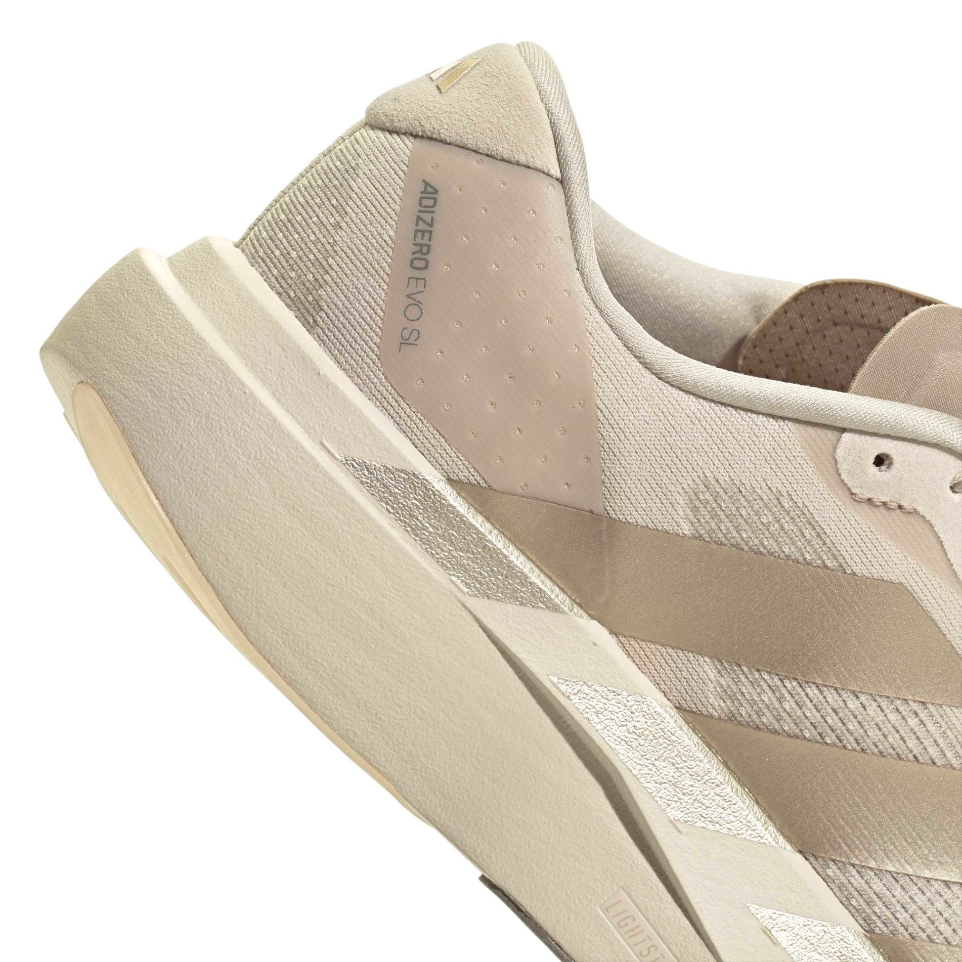 Beige Adidas running shoe on a white background