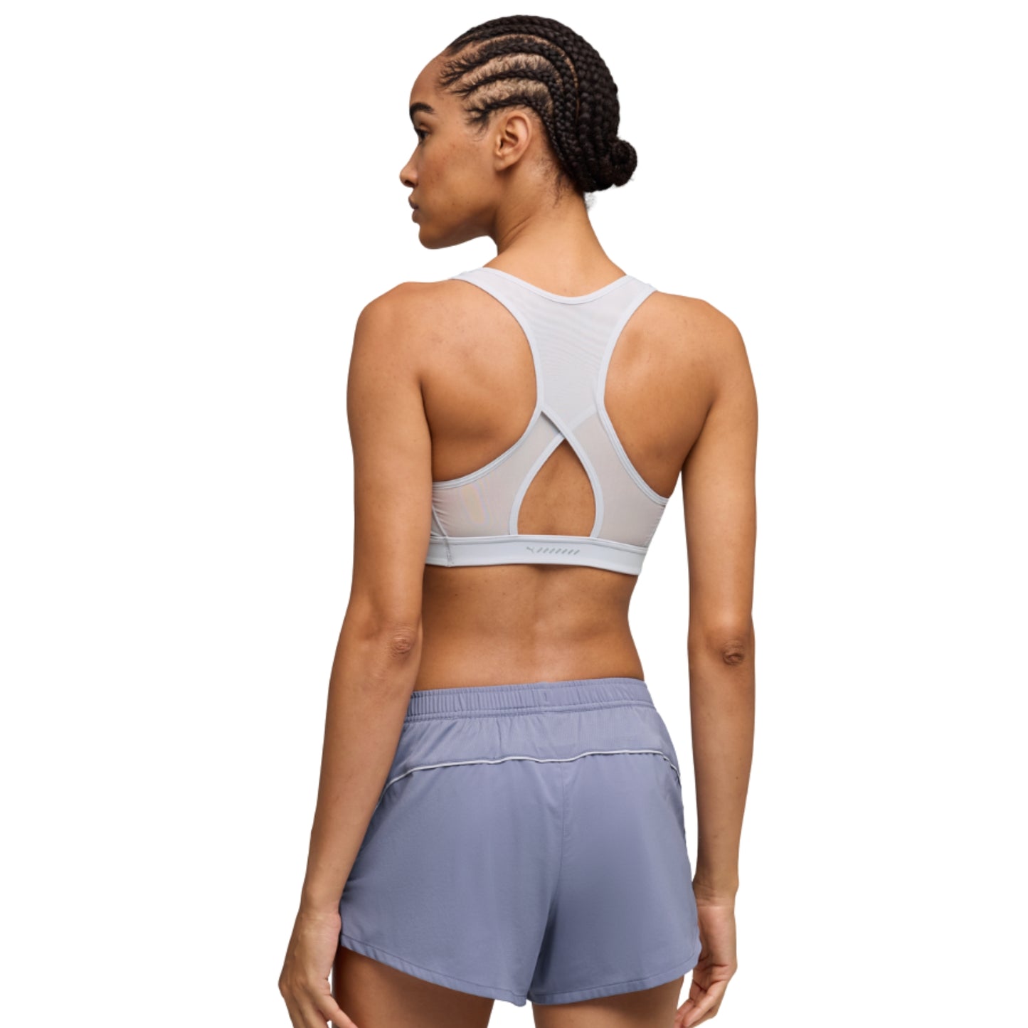 Woman wearing a sports bra and shorts on a white background