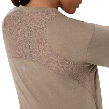 Close-up of a model wearing a beige athletic long-sleeve top, showing the back with a large textured mesh panel across the upper back and shoulders.