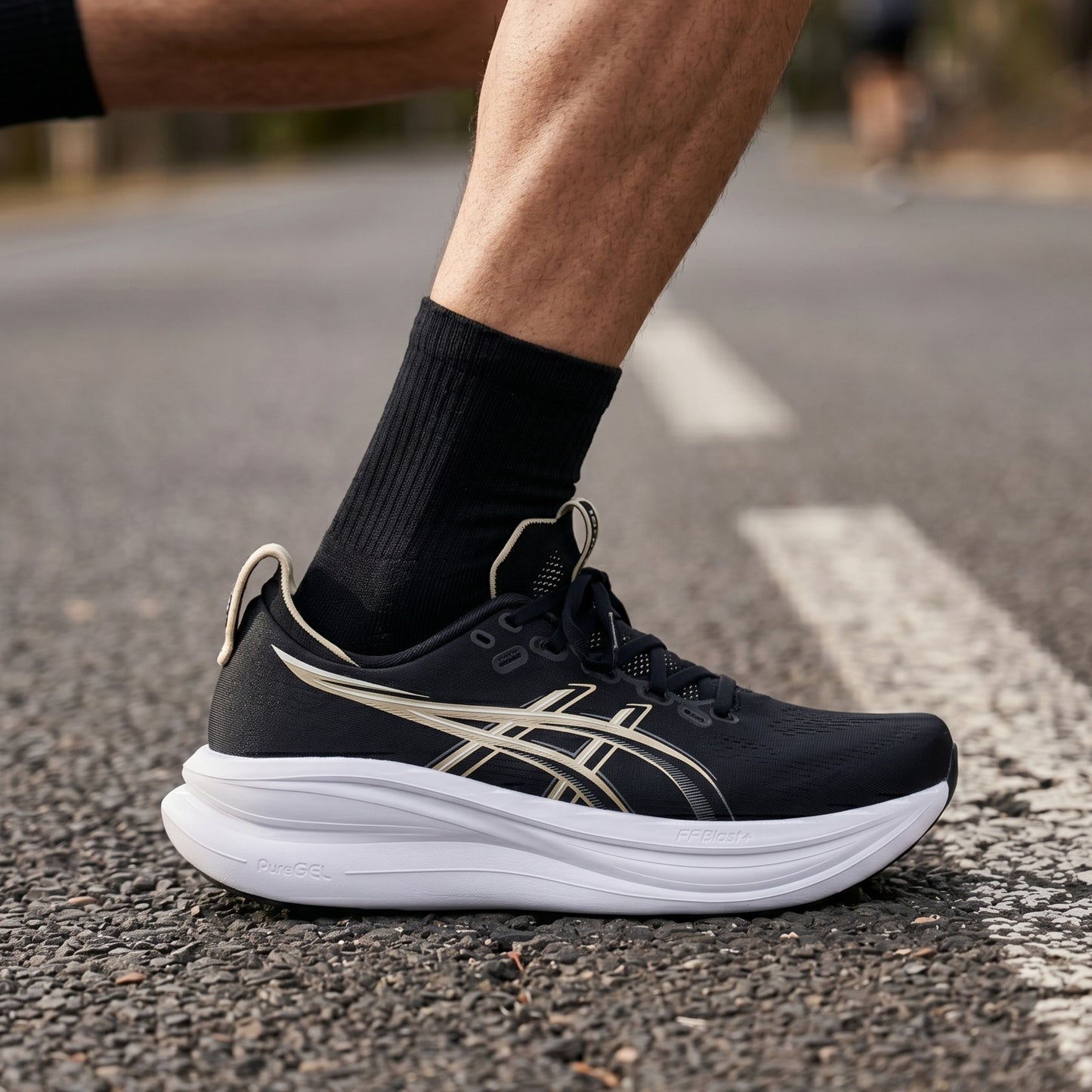 Black running shoe with white sole on a road
