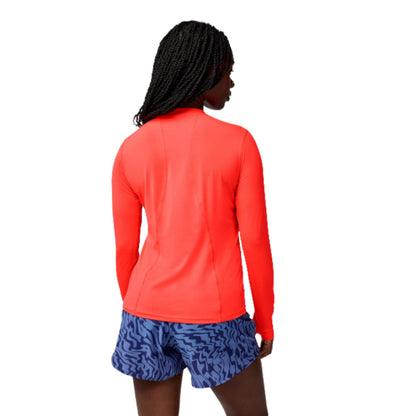 Woman wearing a orange long sleeve shirt on a white background