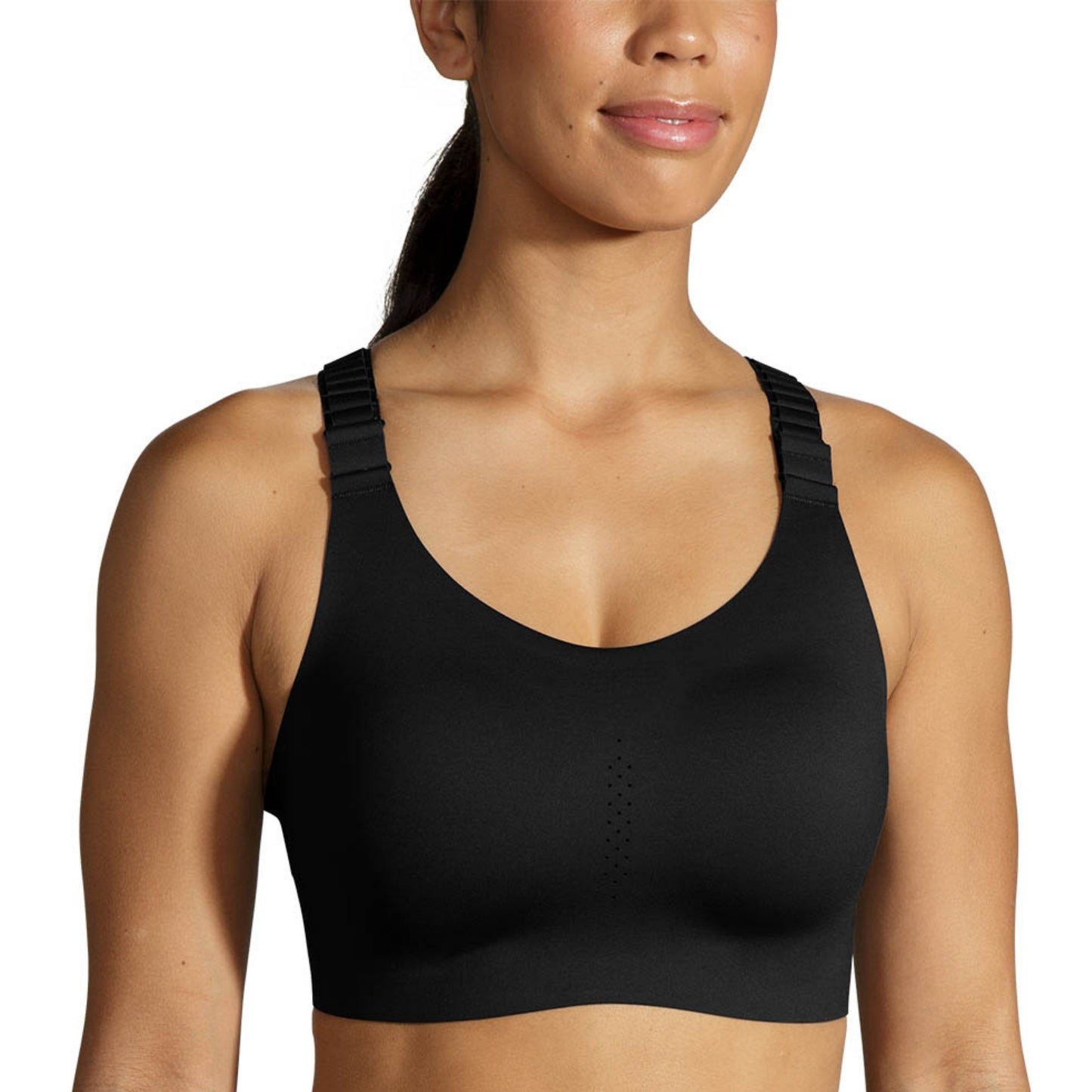 A woman wearing a black sports bra with wide, adjustable shoulder straps, shown from the chest up against a plain white background.