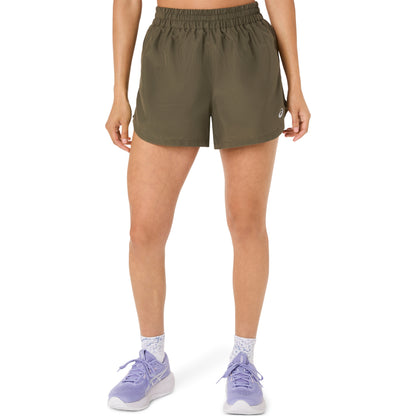 Person wearing olive green Asics shorts on a white background