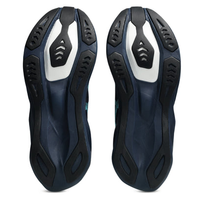 A pair of Asics running shoes shown from the sole view, featuring a dark navy blue and black textured rubber outsole with a prominent white accent panel on each side, set against a plain white background.