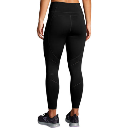Woman wearing a black Brooks legings on a white background