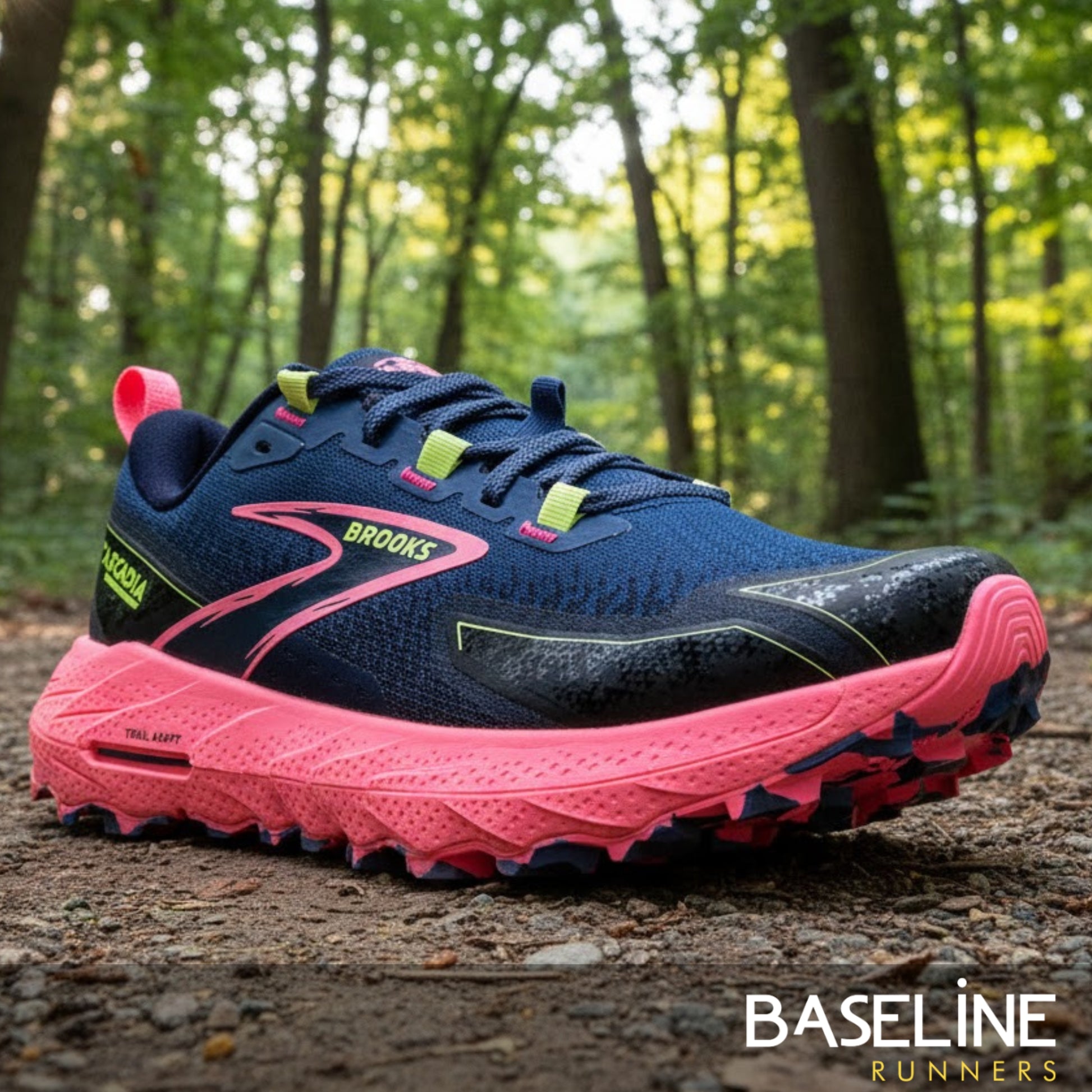 Navy and pink running shoe with 'Brooks' branding on a forest path.