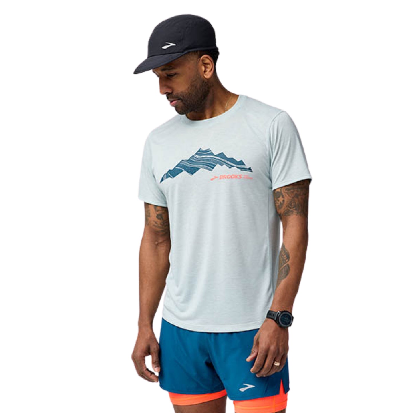 Man wearing a white t-shirt with mountain design and blue shorts on a white background