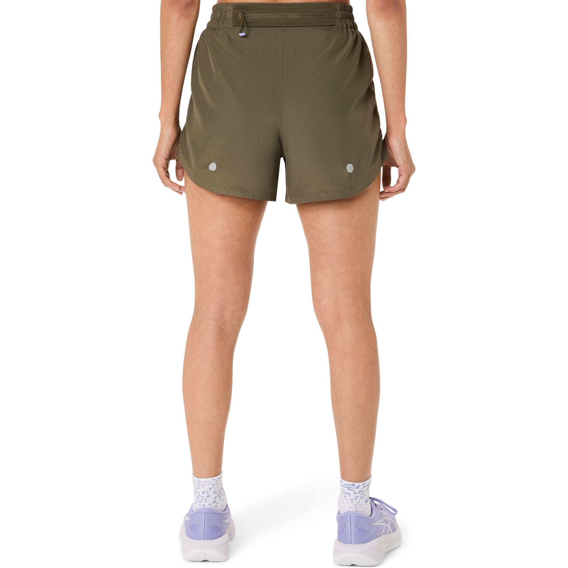 Person wearing olive green Asics shorts on a white background