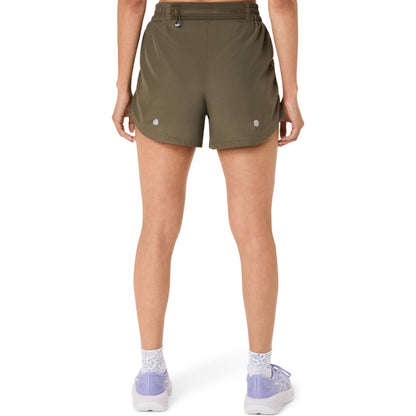 Person wearing olive green Asics shorts on a white background