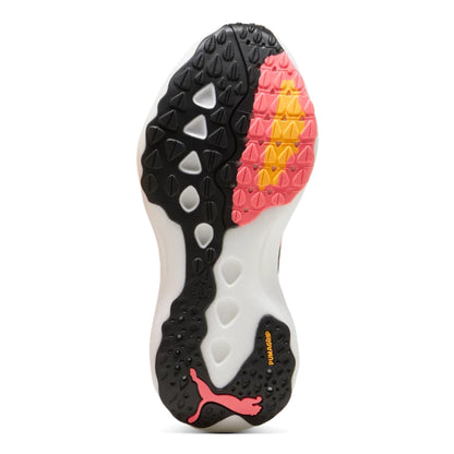 Close-up of a sports shoe sole with black, pink, and yellow patterns on a white background