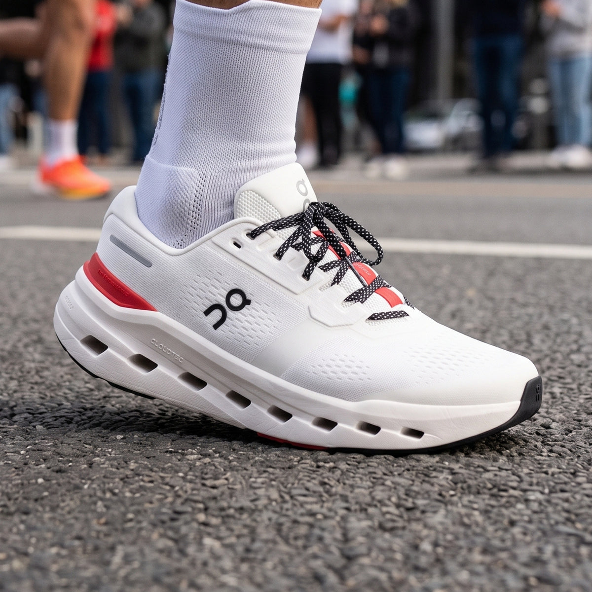 Person wearing white and red with black accents on a road run