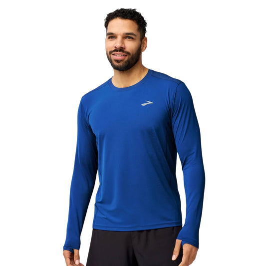 Man wearing a blue Brooks long sleeve shirt on a white background