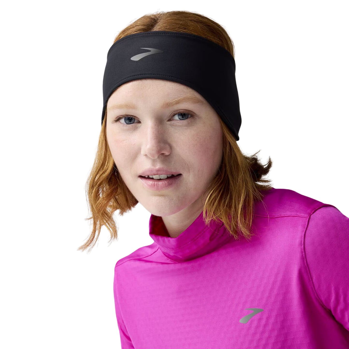 Woman wearing a black Brooks headband on a white background